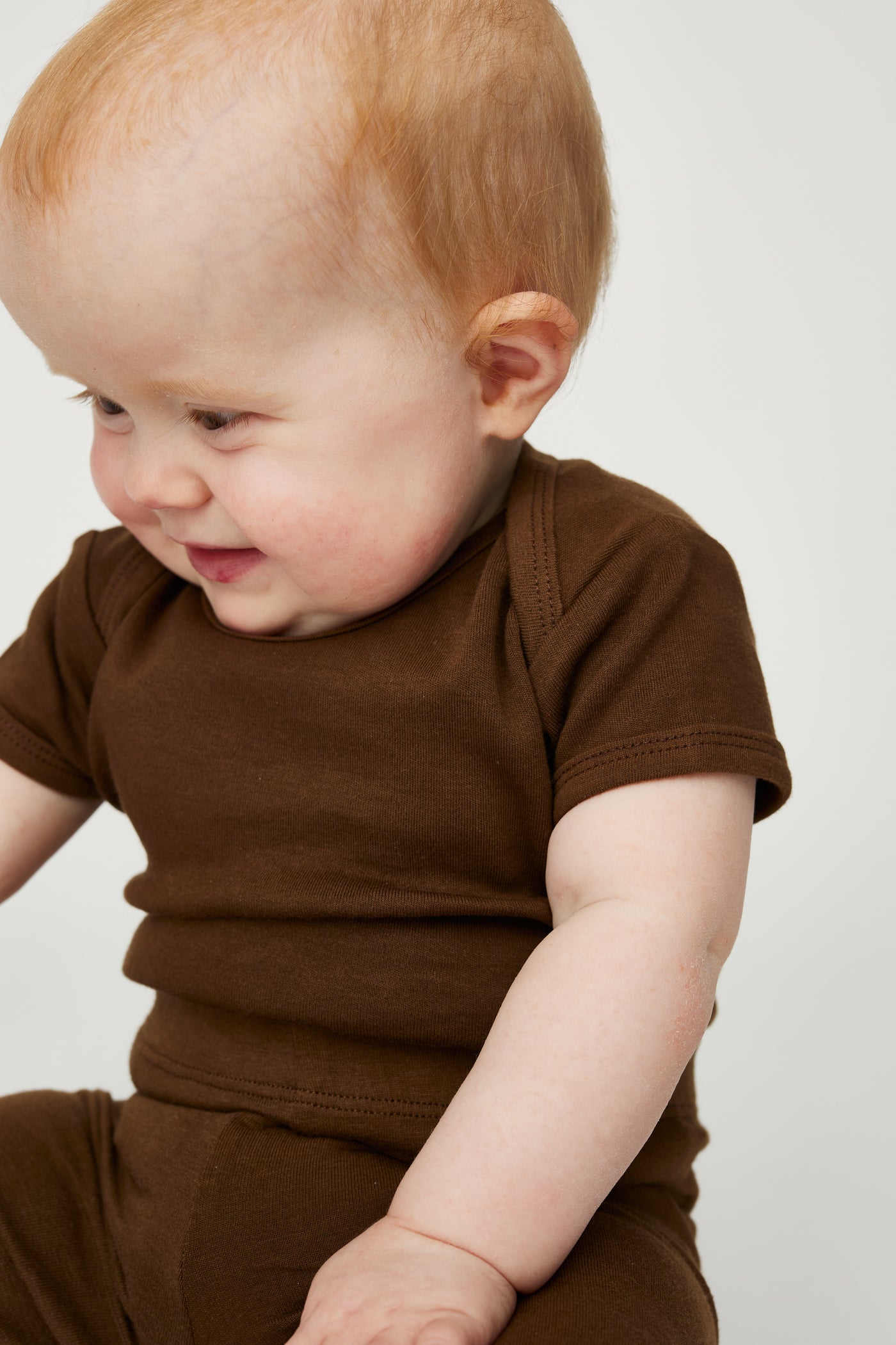 Coffee farvet kortærmet bodystocking i GOTS-certificeret økologisk bomuld fra Organic Lullaby. 