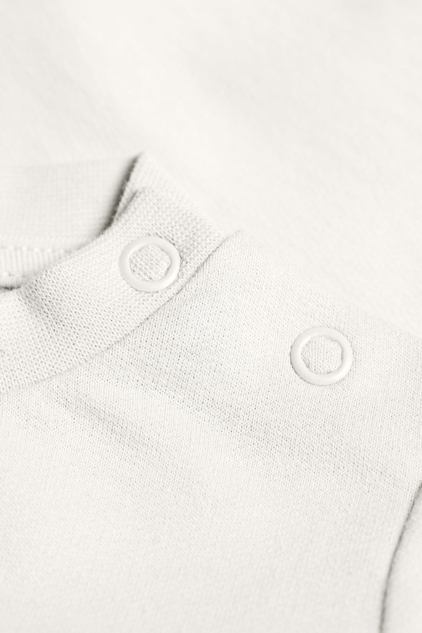 Cremehvid sweatshirt i fleece og med trykknapper ved skulderen i GOTS-certificeret økologisk bomuld fra Organic Lullaby.