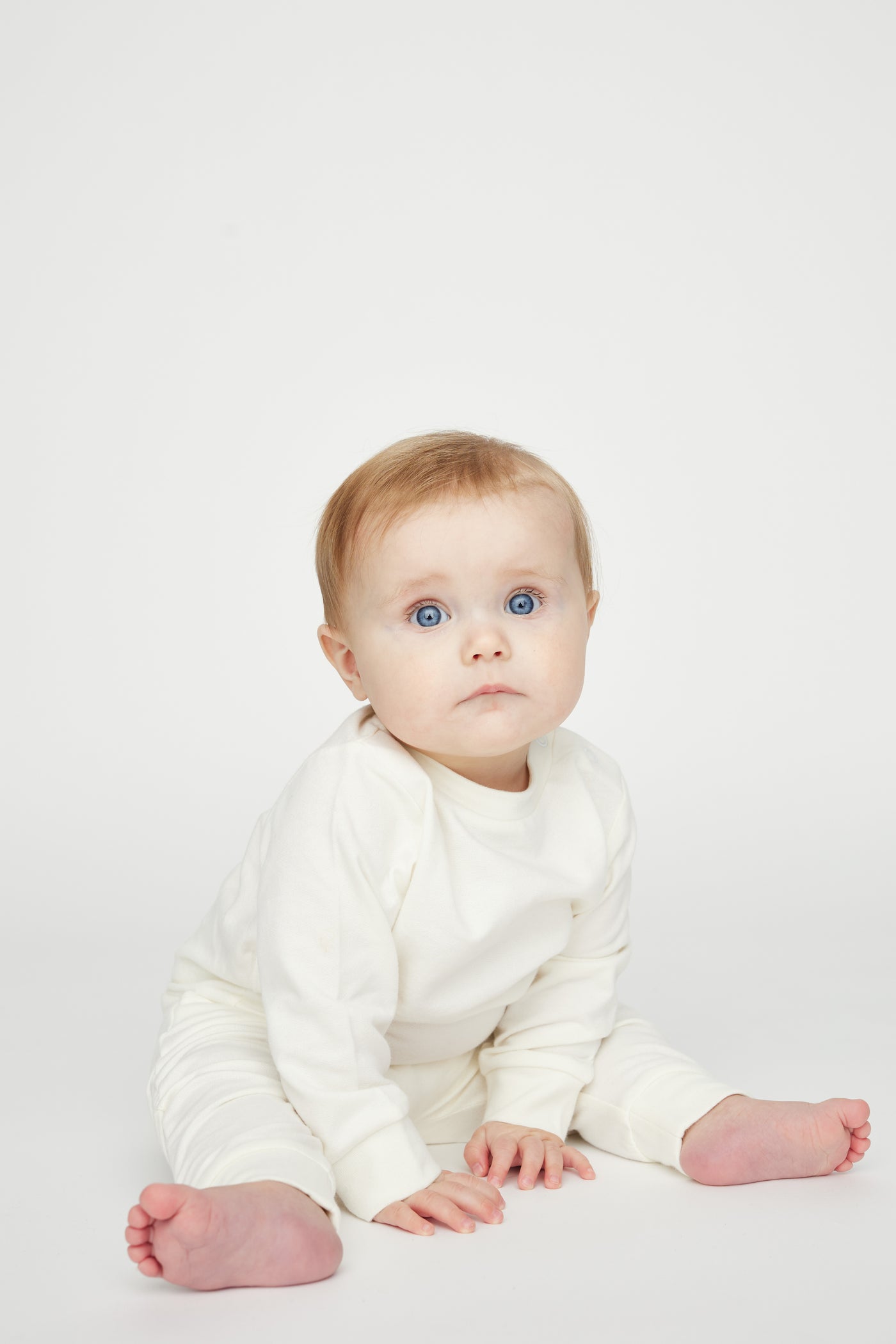 Cremehvid sweatshirt i fleece og med trykknapper ved skulderen i GOTS-certificeret økologisk bomuld fra Organic Lullaby.